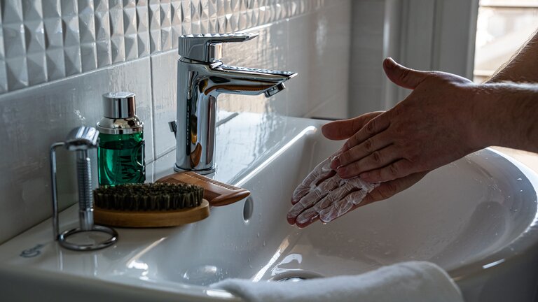 Nahaufnahme von zwei Händen, die mit Seife eingerieben sind, daneben läuft ein Wasserhahn. | © pexels