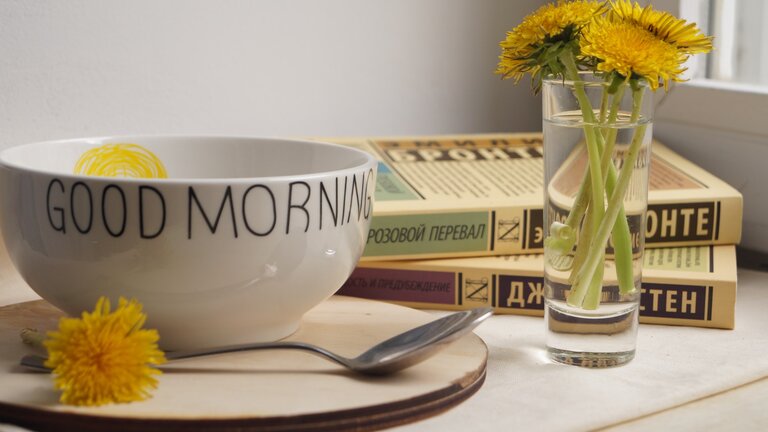 Good-Morning Tasse mit gelben Blumen daneben. | © unsplash