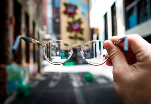 Eine Person hält eine Brille. | © unsplash