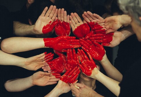 Rotes, aufgemaltes Herz auf vielen Händen. | © unsplash