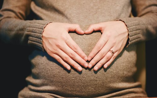 Eine schwangere Frau hält ein mit den Händen geformtes Herz vor ihren Bauch. | © pixabay