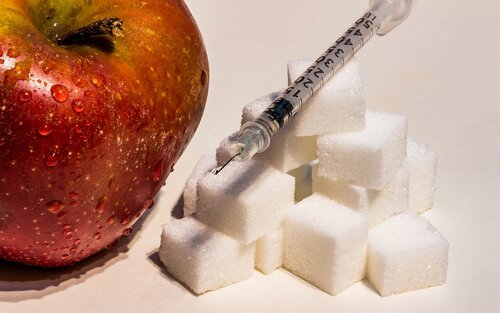 Bild eines Apfels, neben dem Zuckerwürfel und eine Insulinspritze liegen. | © pixabay