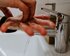 Zwei Hände werden unter fliessendem Wasser aus einem modernen, silbernen Wasserhahn gehalten. Es scheint, als würde sich die Person gründlich die Hände waschen. Der Fokus liegt auf den Händen und dem Wasserhahn, der Hintergrund ist unscharf. | © unsplash