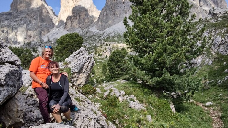 Michael und seine Freundin links im Bild sitzen auf einem Felsen. Im Hintergrund eine Berglandschaft. | © Privataufnahme
