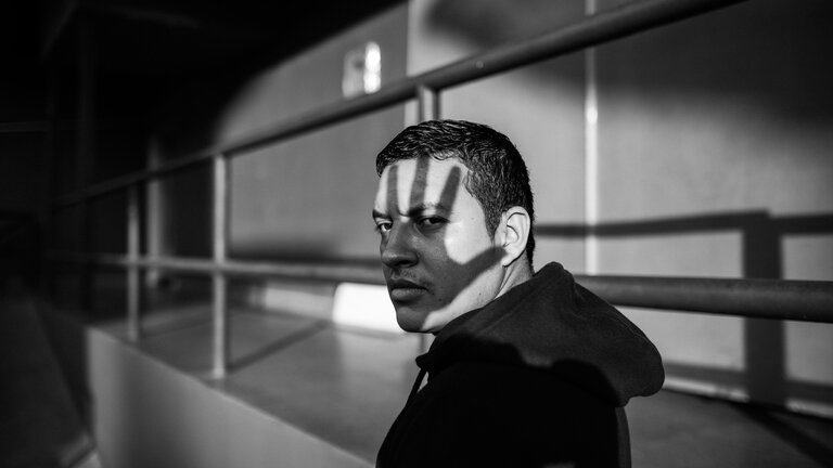 Schwarz -Weiss Foto eines Mannes mit kurzen, dunklen Haaren. Über sein Gesicht fällt der Schatten einer Hand. | © pexels
