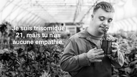Un homme atteint de trisomie 21 sent une plante pendant son travail dans une pépinière. | © Fondation MyHandicap / EnableMe