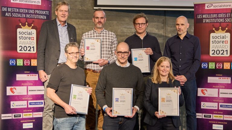 Foto der fünf Gewinner des Socialstore Awards 2021 sowie des Geschäftsführers von Socialstore und dem Moderator der Preisverleihung. | © Stiftung Sovalore