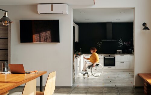 Eine Frau im Rollstuhl in der offenen Küche einer moderne Wohnung. | © pexels