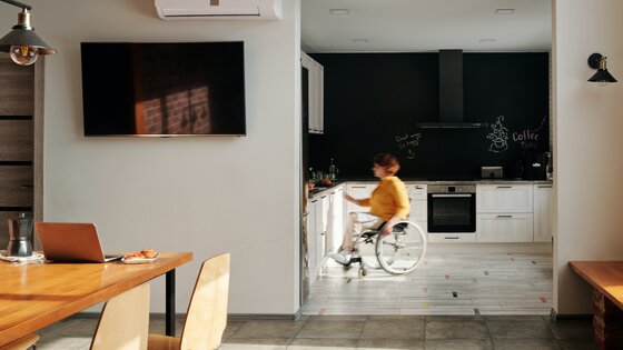 Eine Frau im Rollstuhl in der offenen Küche einer moderne Wohnung. | © Pexels / Marcus Aurelius