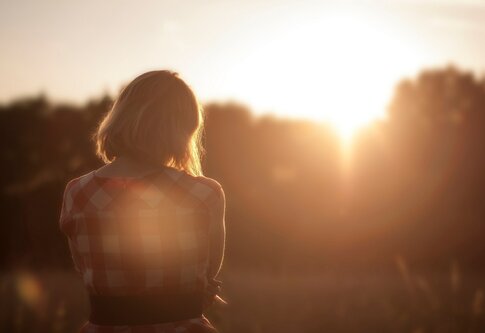 Une femme regarde au loin au lever du soleil. | © pixabay