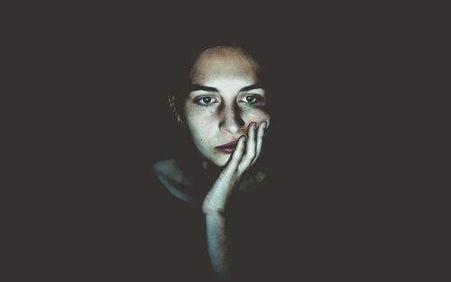 Frau, die im Dunkeln vor einem hellen Bildschirm sitzt | © unsplash