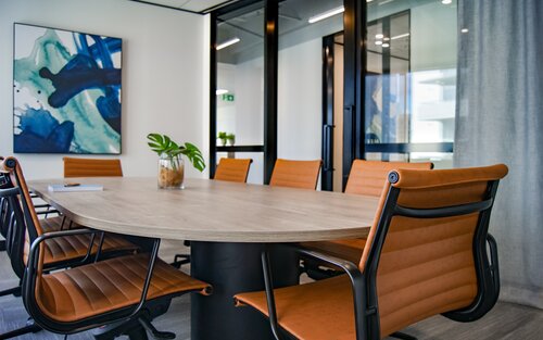 Foto eines leeren Sitzungszimmers mit einem runden Tisch und Stühlen. | © unsplash