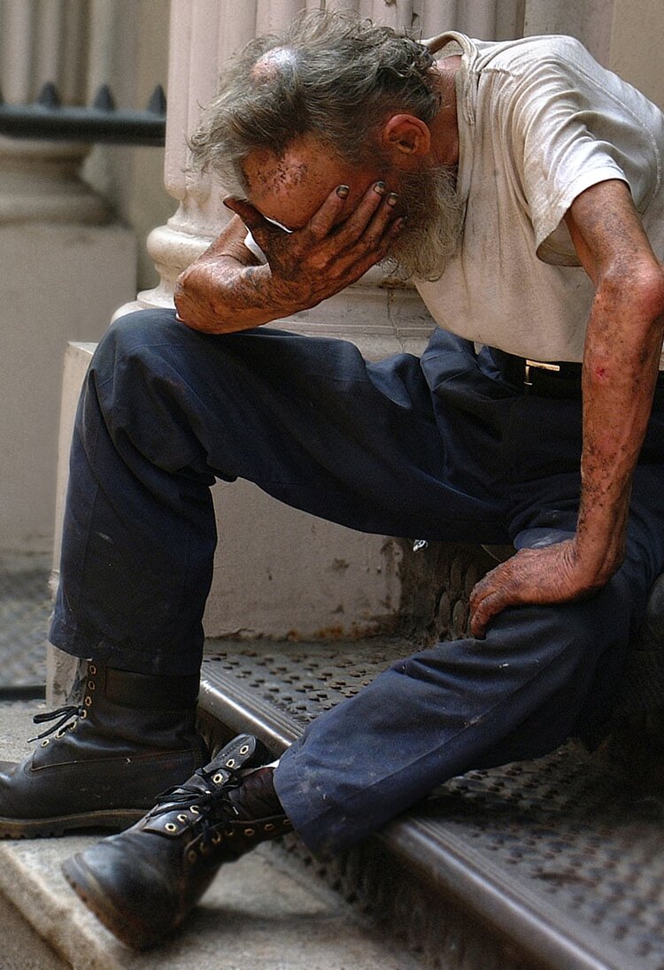 Ein älterer ungepflegter Herr sitzt auf der Treppe vor einem Haus und weint.  | © unsplash