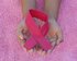 Frau hält Krebs Besiegen Symbol in den Händen | © unsplash