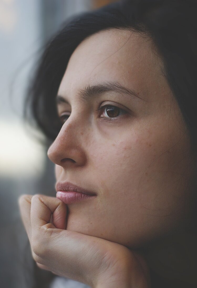 Nahaufnahme des Gesichts einer Frau, die nachdenklich aus dem Fenster schaut | © pixabay