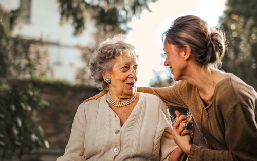 Ältere Frau und ihre erwachsene Tochter grüssen sich lachend. | © pexels