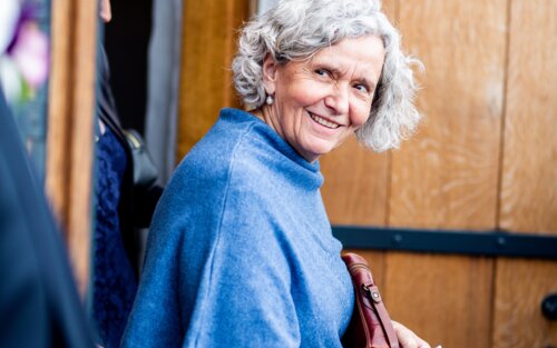 Eine ältere Frau im blauen Pullover lächelt in die Kamera. | © pexels