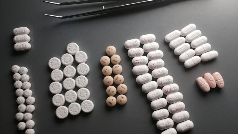 sortierte Tabletten, die neben einer Pinzette liegen | © unsplash