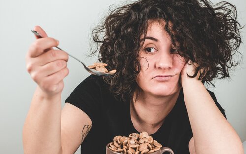 Foto einer Frau, die einen Löffel mit Cerealien anschaut. | © unsplash