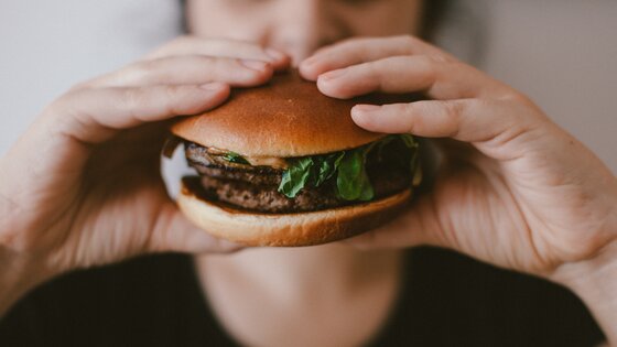 Person hält Burger in ihren Händen | © Unsplash