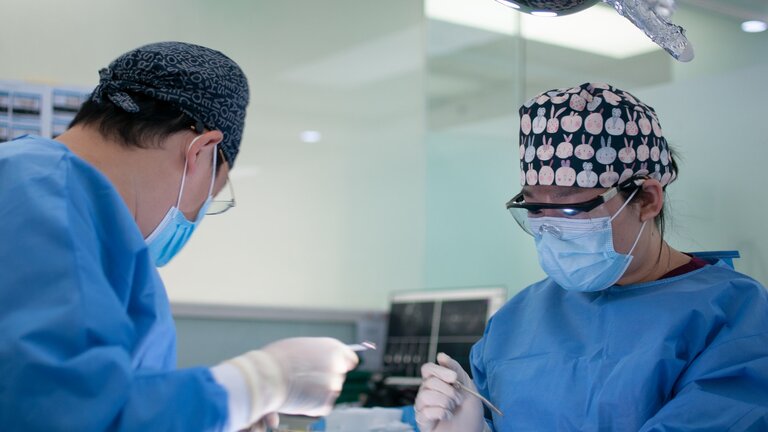 Foto von zwei Ärzten, die gerade eine Operation durchführen. | © unsplash
