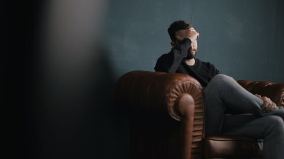 Ein Mann sitzt auf dem Sofa und  | © Unsplash