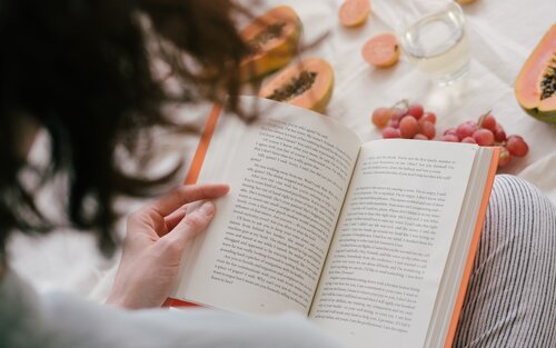 Foto einer Frau mit aufgeschlagenem Buch auf dem Schoss. | © pexels