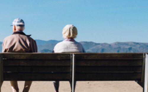 Homme et femme assis sur un banc avec la vue sur la mer. | © unsplash