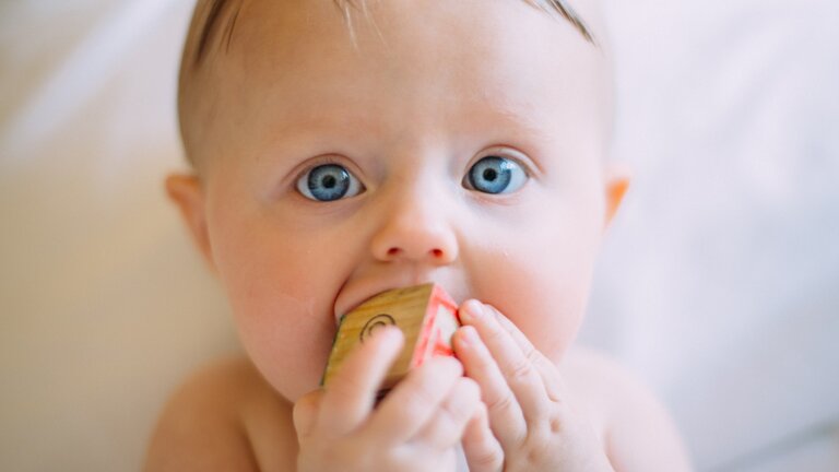 Bébé avec des dés jouet dans la bouche. | © Unsplash