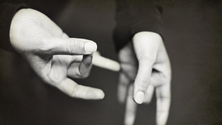 Une femme fait un signe de la langue des signes.  | © Unsplash