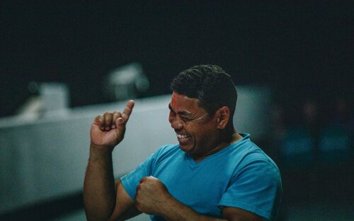 Ein Mann in einem blauen T-Shirt lacht und streckt seinen rechten Zeigefinger nach oben.  | © unsplash
