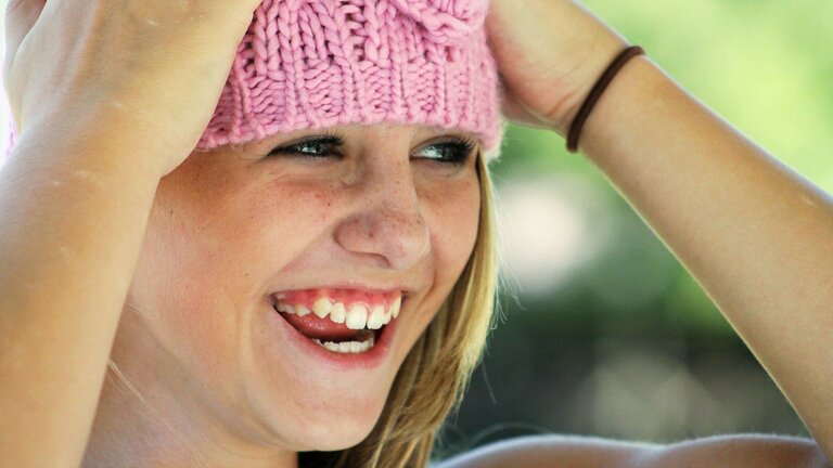 Ein lachendes Mädchen mit rosa Strickmütze. | © pixabay