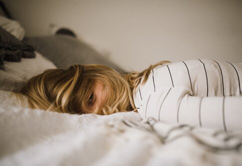 Frau, die auf dem Bett liegt und nicht schlafen kann. | © unsplash