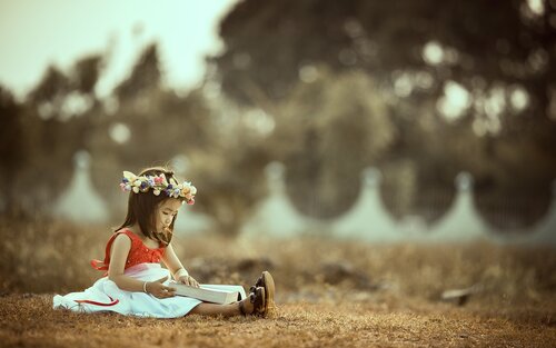Kleines Mädchen liest draussen ein Buch.  | © pixabay