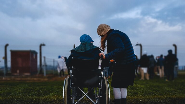 Une personne âgée en fauteuil roulant parle à sa fille à ses côtés | © unsplash