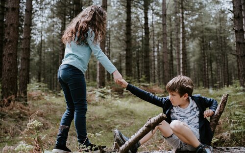 Mädchen hilft Junge im Wald. | © unsplash