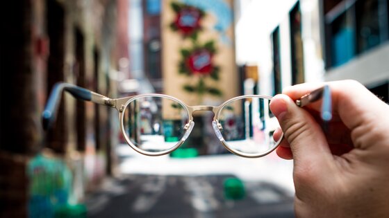 Une personne tient des lunettes. | © Josh Calabrese/unsplash