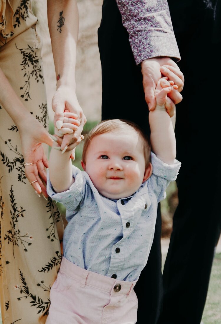Eltern, die ihr Kleinkind an den Händen halten | © unsplash