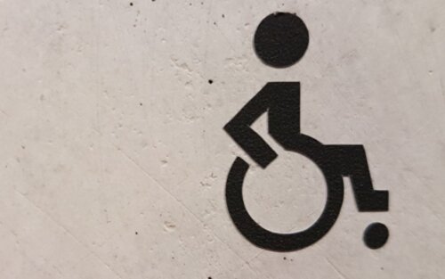Schwarzer Rollstuhl auf weisse Wand gesprüht | © unsplash