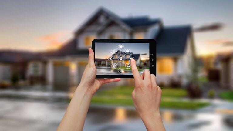 Un smartphone est présenté devant une maison intelligente. | © BRACK.CH