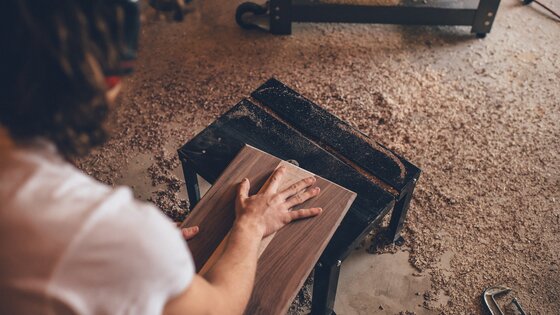 Person arbeitet mit Holz in einer Werkstatt. | © unsplash