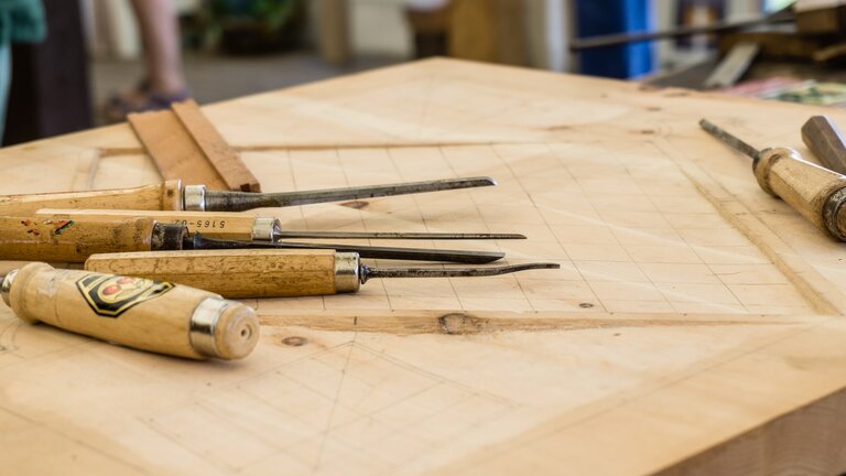 Divers outils sur une table dans un atelier. | © Unsplash