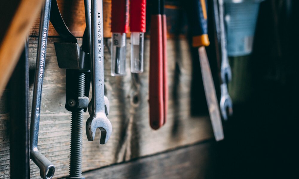 Werkzeuge hängen an einer Holzwand. | © unsplash