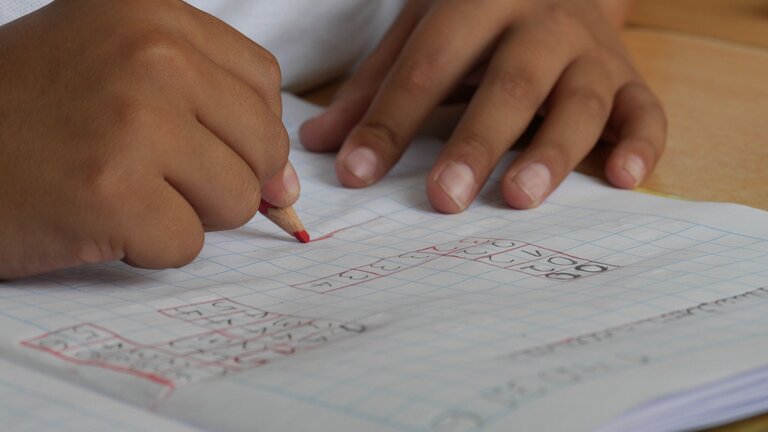 Ein Kind löst Aufgaben in einem Hausaufgabenheft. | © pexels