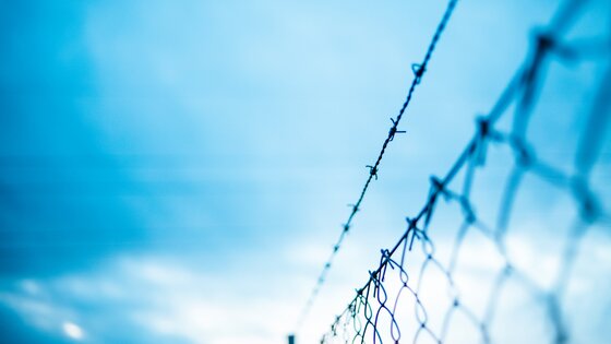 Ein Zaun, durch den man den blauen Himmel sieht. | © Unsplash