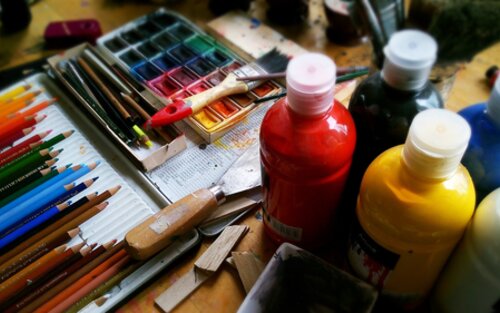 Künstlerequipment wie Farben und Pinsel auf einem Tisch. | © pixabay