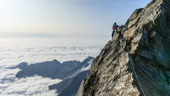 Person klettert eine steile Felswand hoch. | © Unsplash