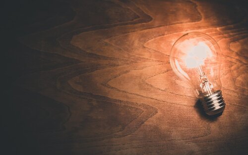 Eine leuchtende Glühbirne auf braunem Hintergrund.  | © pixabay