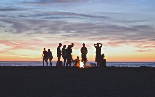 Eine Gruppe von Menschen um ein Lagerfeuer.  | © unsplash
