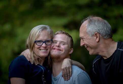 Un fils en situation de handicap est enlacé par ses parents. | © unsplash